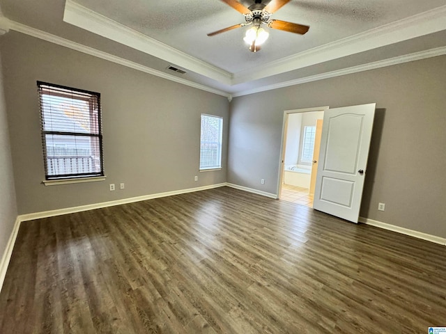 unfurnished room with a raised ceiling, crown molding, ceiling fan, and dark hardwood / wood-style floors