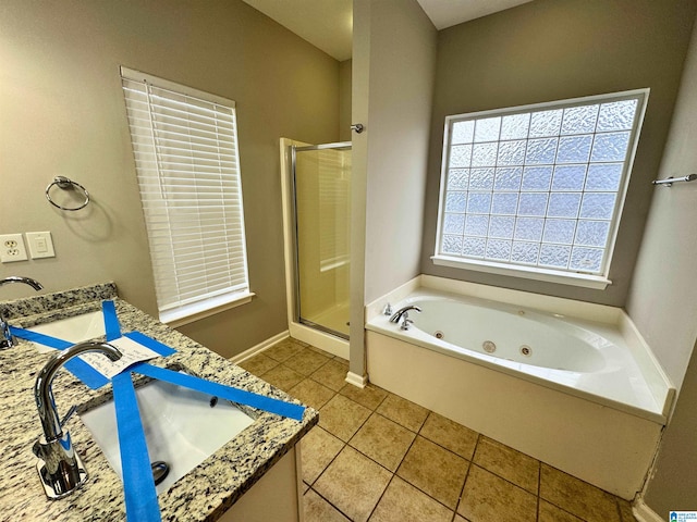 bathroom with tile patterned flooring, vanity, and plus walk in shower