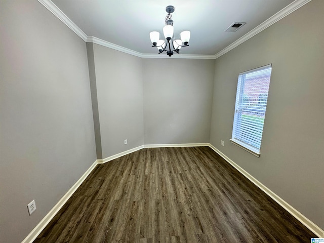 spare room featuring dark hardwood / wood-style floors, ornamental molding, and an inviting chandelier