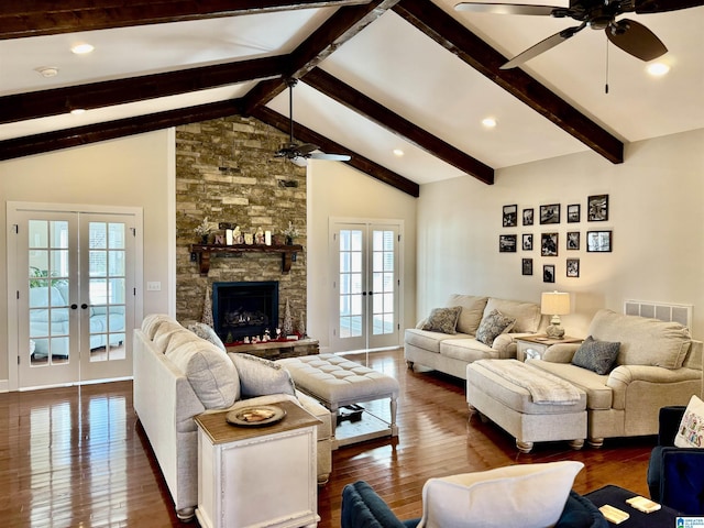 living room with lofted ceiling with beams, dark hardwood / wood-style flooring, a fireplace, and french doors