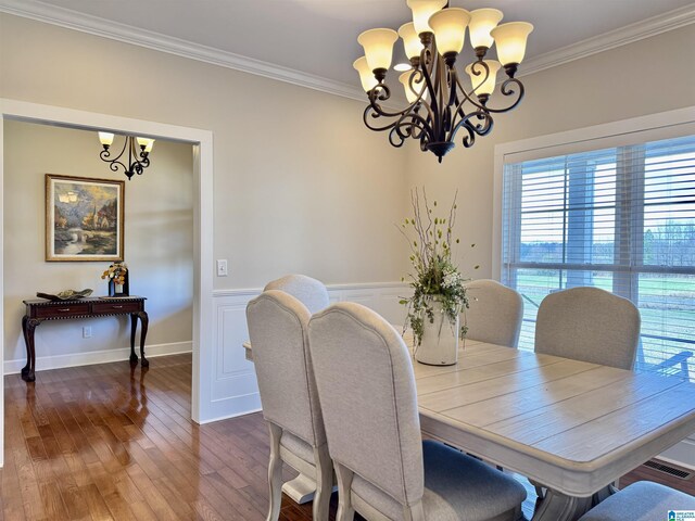 dining area featuring wood-type flooring, crown molding, and an inviting chandelier