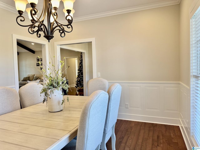 dining room with dark hardwood / wood-style floors, crown molding, and an inviting chandelier