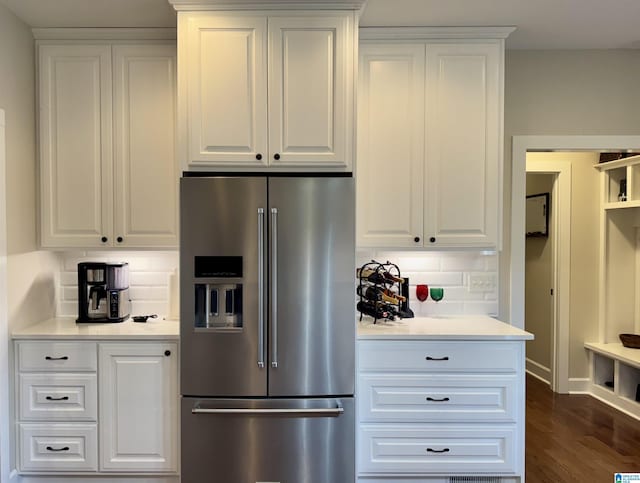 kitchen with stainless steel refrigerator with ice dispenser, tasteful backsplash, white cabinetry, and dark hardwood / wood-style floors