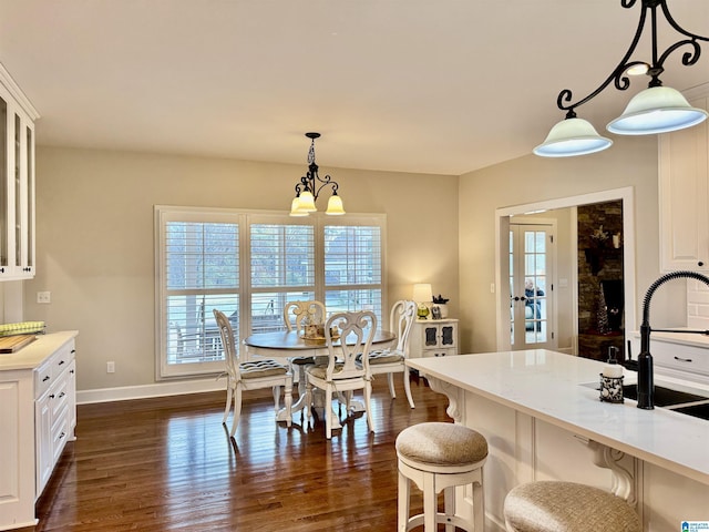 dining area with a chandelier, dark hardwood / wood-style flooring, and sink