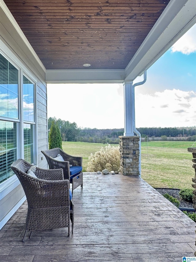 deck with a yard and a rural view