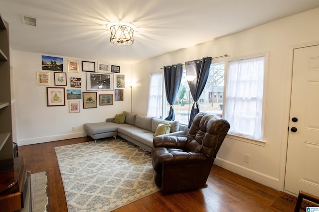 living room with dark wood-type flooring and an inviting chandelier