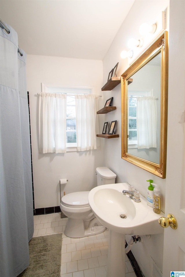 bathroom with tile patterned floors, a wealth of natural light, and toilet