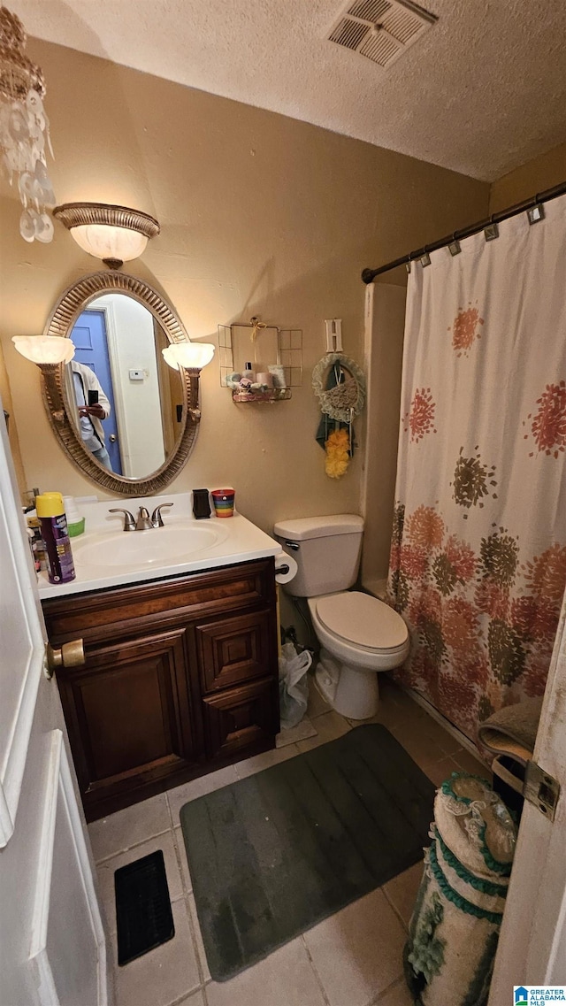 bathroom with tile patterned floors, a shower with curtain, vanity, a textured ceiling, and toilet