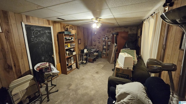 interior space with a drop ceiling and wooden walls