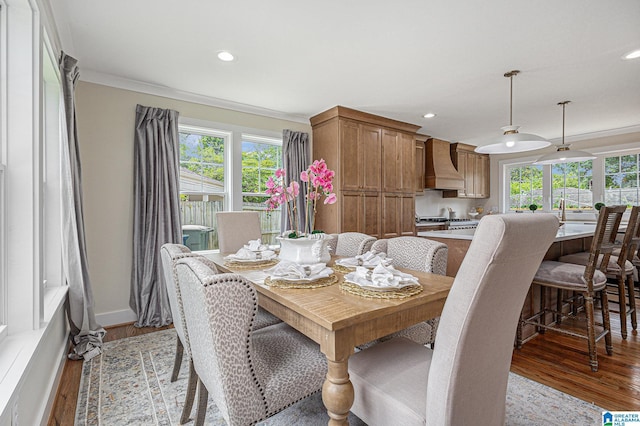 dining space featuring light wood-type flooring and crown molding