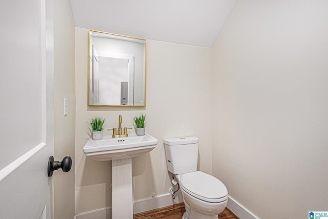 bathroom with hardwood / wood-style floors and toilet