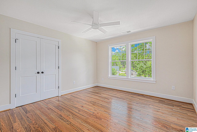 unfurnished bedroom featuring ceiling fan, a closet, and light hardwood / wood-style flooring