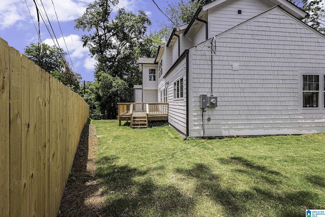 view of home's exterior with a wooden deck and a yard