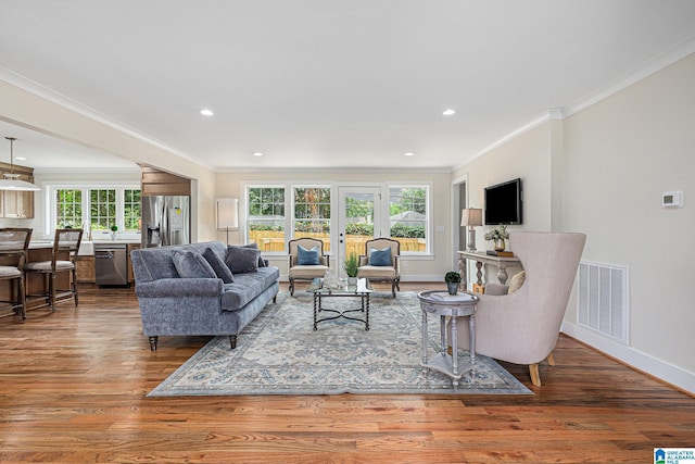 living room with crown molding, a healthy amount of sunlight, and hardwood / wood-style flooring