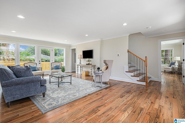 living room with ornamental molding, a healthy amount of sunlight, and hardwood / wood-style flooring