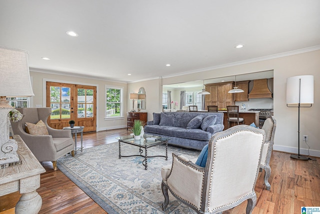 living room with french doors, hardwood / wood-style floors, and ornamental molding