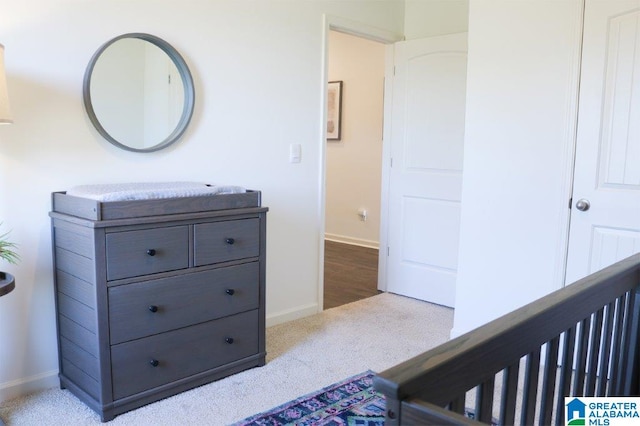 carpeted bedroom featuring a nursery area