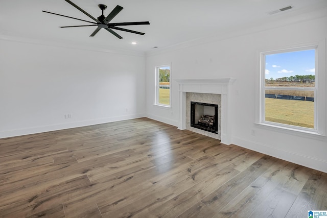 unfurnished living room featuring a wealth of natural light, crown molding, light hardwood / wood-style flooring, and ceiling fan