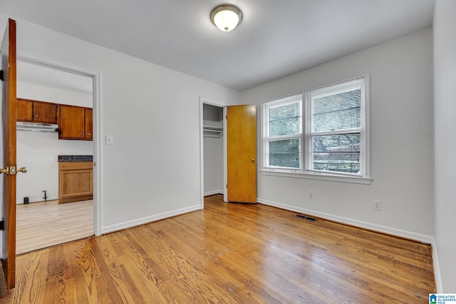 unfurnished bedroom featuring light hardwood / wood-style floors and a closet