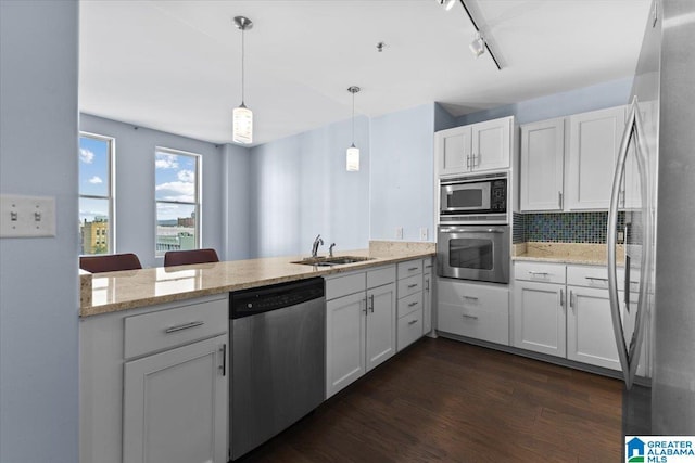 kitchen featuring stainless steel appliances, white cabinetry, kitchen peninsula, and decorative light fixtures