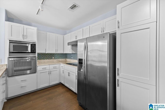 kitchen featuring backsplash, white cabinets, dark wood-type flooring, rail lighting, and stainless steel appliances