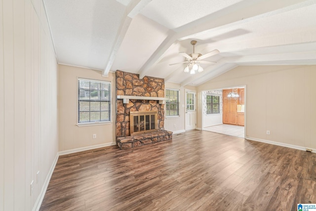 unfurnished living room featuring ceiling fan, a stone fireplace, plenty of natural light, and wood-type flooring