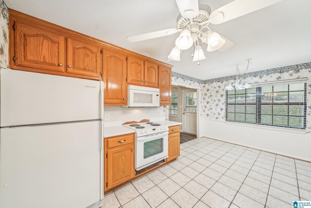 kitchen featuring a textured ceiling, ceiling fan, light tile patterned floors, and white appliances