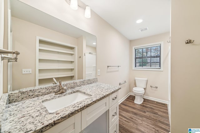 bathroom featuring vanity, wood-type flooring, and toilet