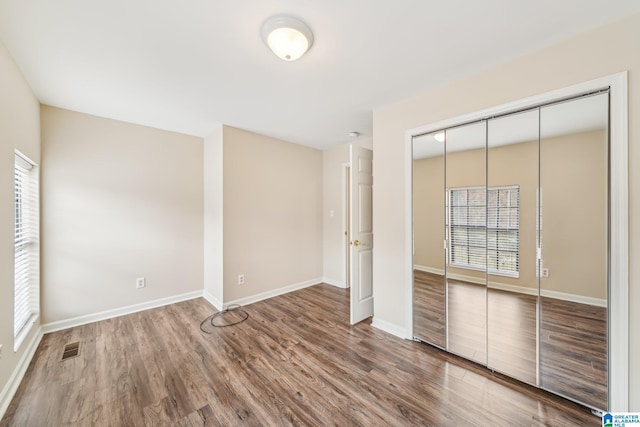 unfurnished bedroom featuring hardwood / wood-style floors and a closet