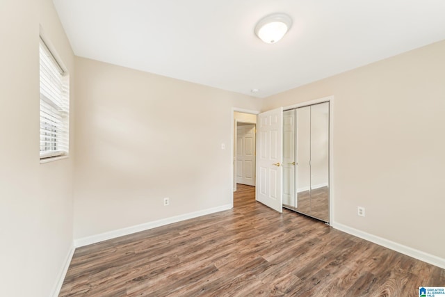 unfurnished bedroom featuring hardwood / wood-style floors and a closet