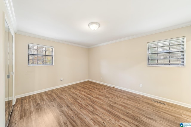 unfurnished room featuring hardwood / wood-style flooring and crown molding