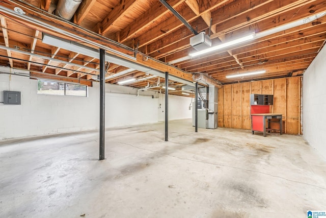 basement featuring electric panel and heating unit