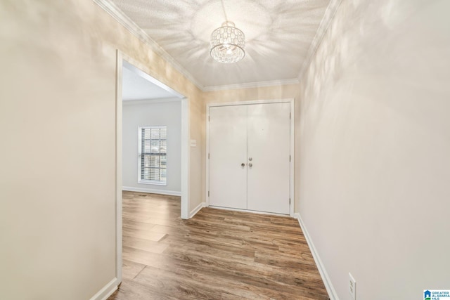 hall with a notable chandelier, crown molding, and light hardwood / wood-style flooring