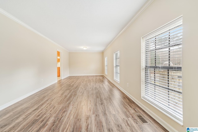 empty room with light hardwood / wood-style flooring and ornamental molding