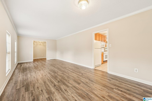 unfurnished room featuring light hardwood / wood-style floors, ornamental molding, and a textured ceiling