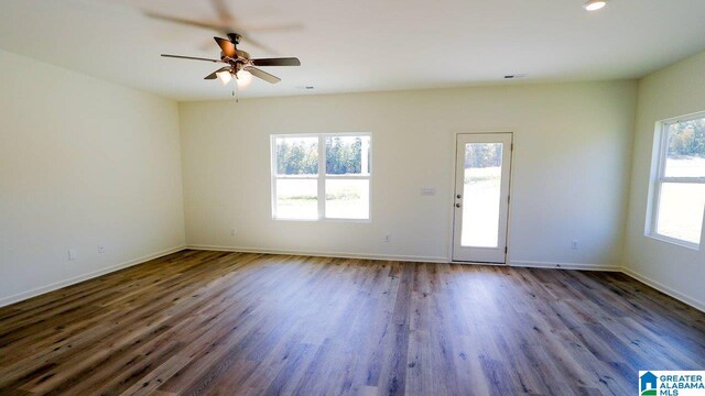 unfurnished room with ceiling fan and dark hardwood / wood-style flooring