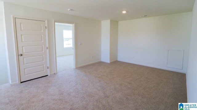 unfurnished room featuring light carpet