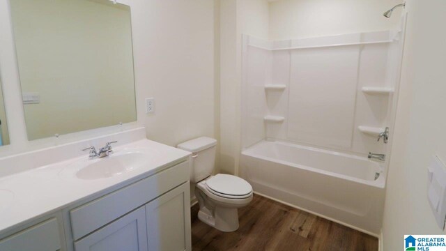 full bathroom with vanity, shower / bath combination, hardwood / wood-style flooring, and toilet