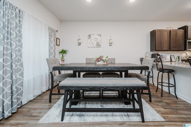 dining space featuring sink and light hardwood / wood-style flooring