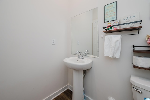 bathroom with hardwood / wood-style flooring, toilet, and sink