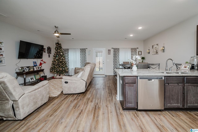 kitchen with dishwasher, dark brown cabinets, sink, and light hardwood / wood-style flooring