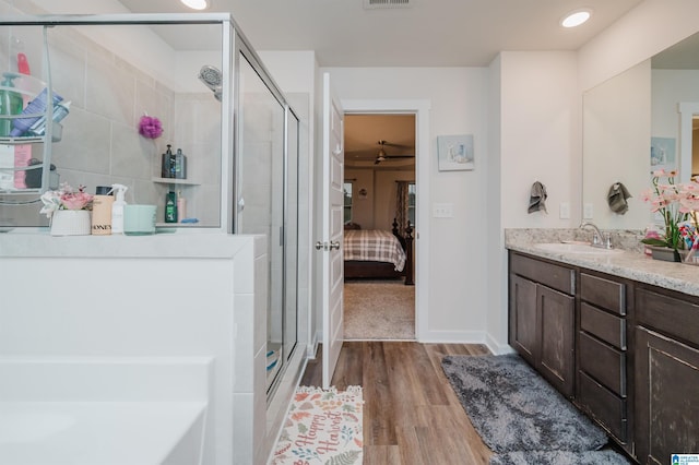 bathroom with hardwood / wood-style floors, vanity, and walk in shower