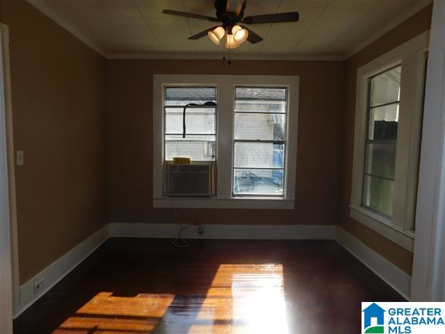 spare room with dark hardwood / wood-style floors, ceiling fan, and crown molding