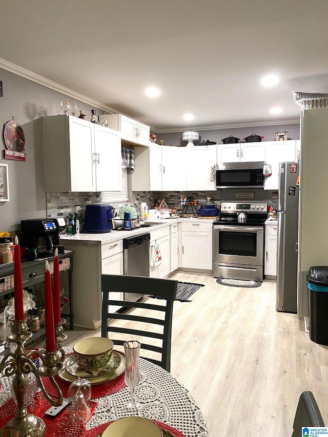 kitchen featuring white cabinets, backsplash, and stainless steel appliances