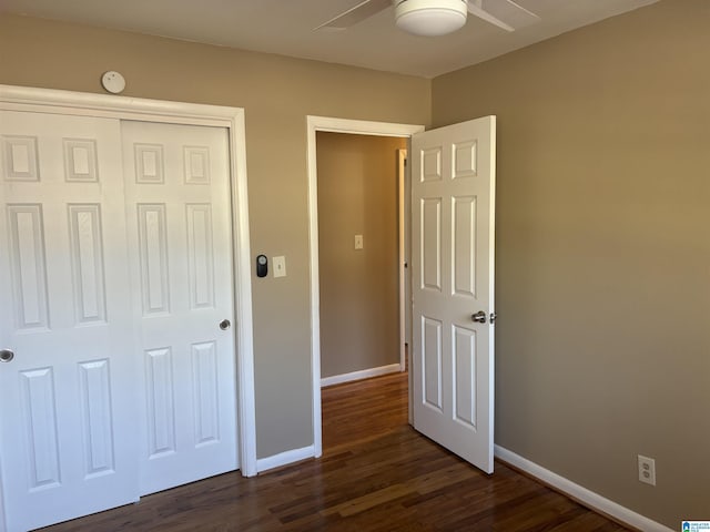 unfurnished bedroom with ceiling fan, a closet, and dark hardwood / wood-style floors