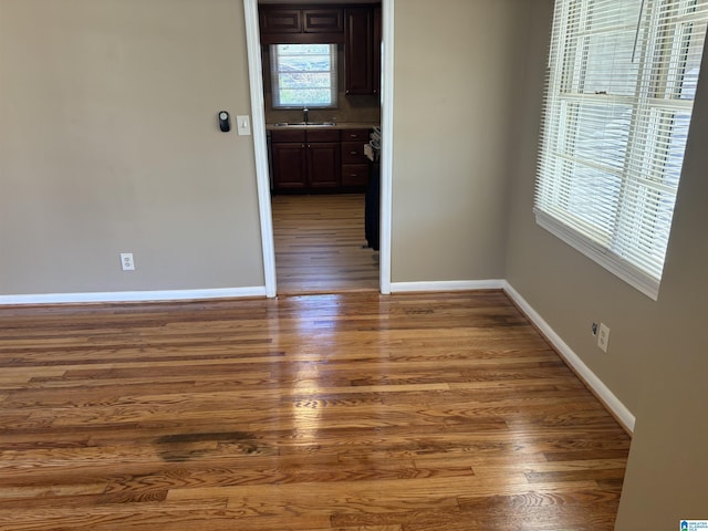 unfurnished room with dark hardwood / wood-style floors and sink