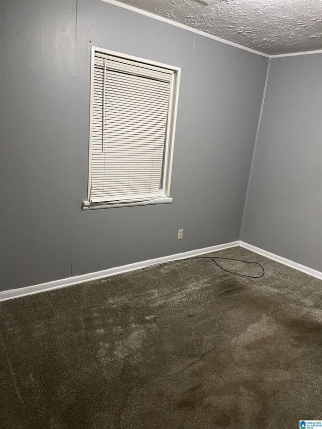 carpeted empty room featuring a textured ceiling