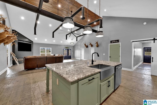 kitchen featuring high vaulted ceiling, stainless steel dishwasher, a kitchen island with sink, and sink