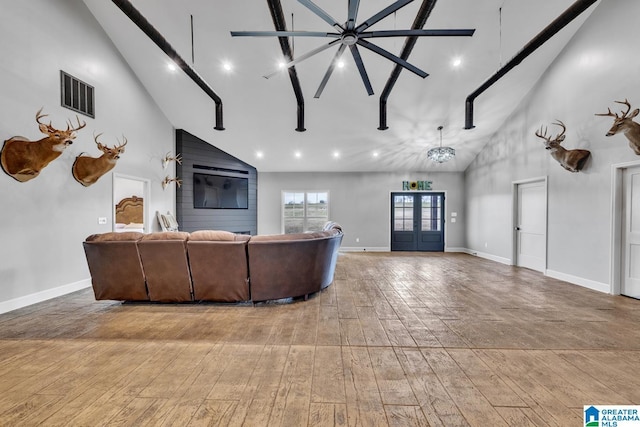 living room with hardwood / wood-style flooring, french doors, high vaulted ceiling, and a chandelier