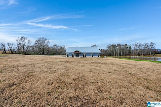 view of front facade with a water view and a front lawn